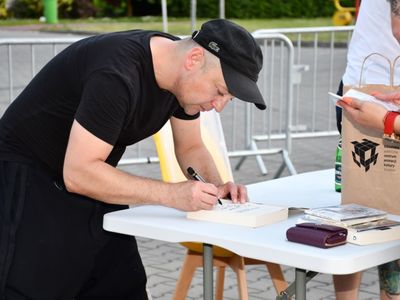 Czesław Mozil podpisujący książkę