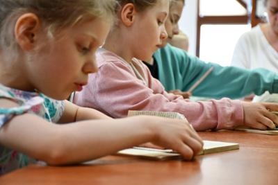 Warsztaty dla dzieci z rzeźbienia w książkach - uczestniczki podczas pracy