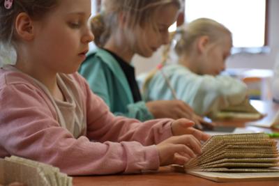 Warsztaty dla dzieci z rzeźbienia w książkach - uczestniczki podczas pracy
