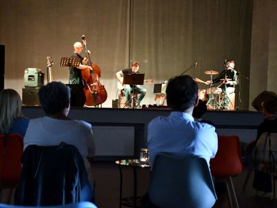 Na pierwszym planie publiczność; w tle na scenie od lewej: Zbigniew Wrombel (kontrabas), Witold Żuromski (gitara), Andrzej Mazurek (perkusja)