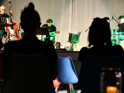 Na pierwszym planie publiczność; w tle na scenie od lewej: Zbigniew Wrombel (kontrabas), Witold Żuromski (gitara), Andrzej Mazurek (perkusja)