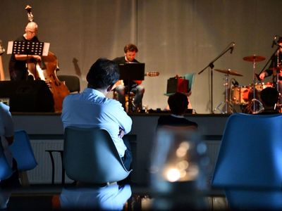 Na pierwszym planie publiczność; w tle na scenie od lewej: Zbigniew Wrombel (kontrabas), Witold Żuromski (gitara), Andrzej Mazurek (perkusja)