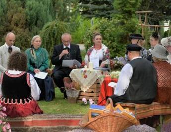 Lektorzy akcji Narodowego Czytania na tle scenografii w ogrodzie przy szkole w Liśniku Dużym