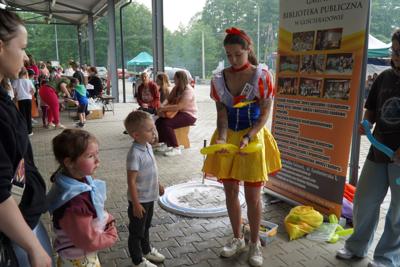 Biblioteczna Śnieżka konstruuje figurki z baloników dla uczestników Dnia Dziecka.