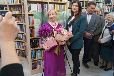 Pani Jolanta Witek z kwiatami pośród osób zwiedzających.
