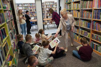 Pani dyrektor Dorota Karkusiewicz przekazuje małym uczestnikom  warsztatów egzemplarze książki o Plamku i Brudku jako motywację do tworzenia własnych biblioteczek przez dzieci.