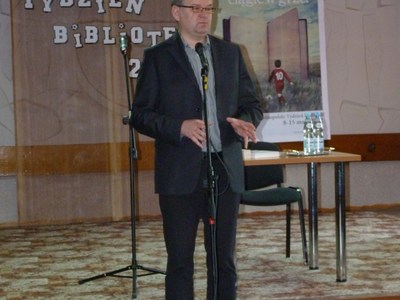 Artur Andrus opowiada o książce czytelnikom biblioteki.