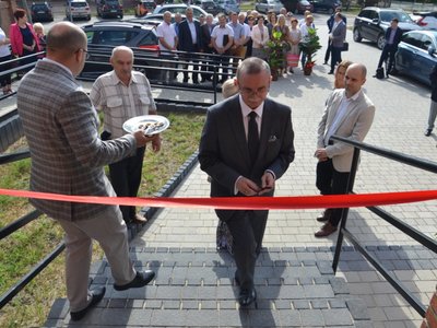 Mariusz Szczepanik podchodzi do przecięcia wstęgi.