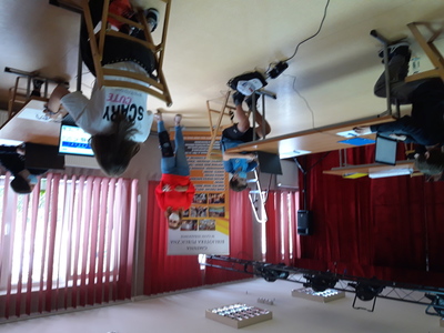 Prowadząca szkolenie trener z Centrum "Mentoris" Mateusz Prucnal z częścią uczestników na tle banneru biblioteki.