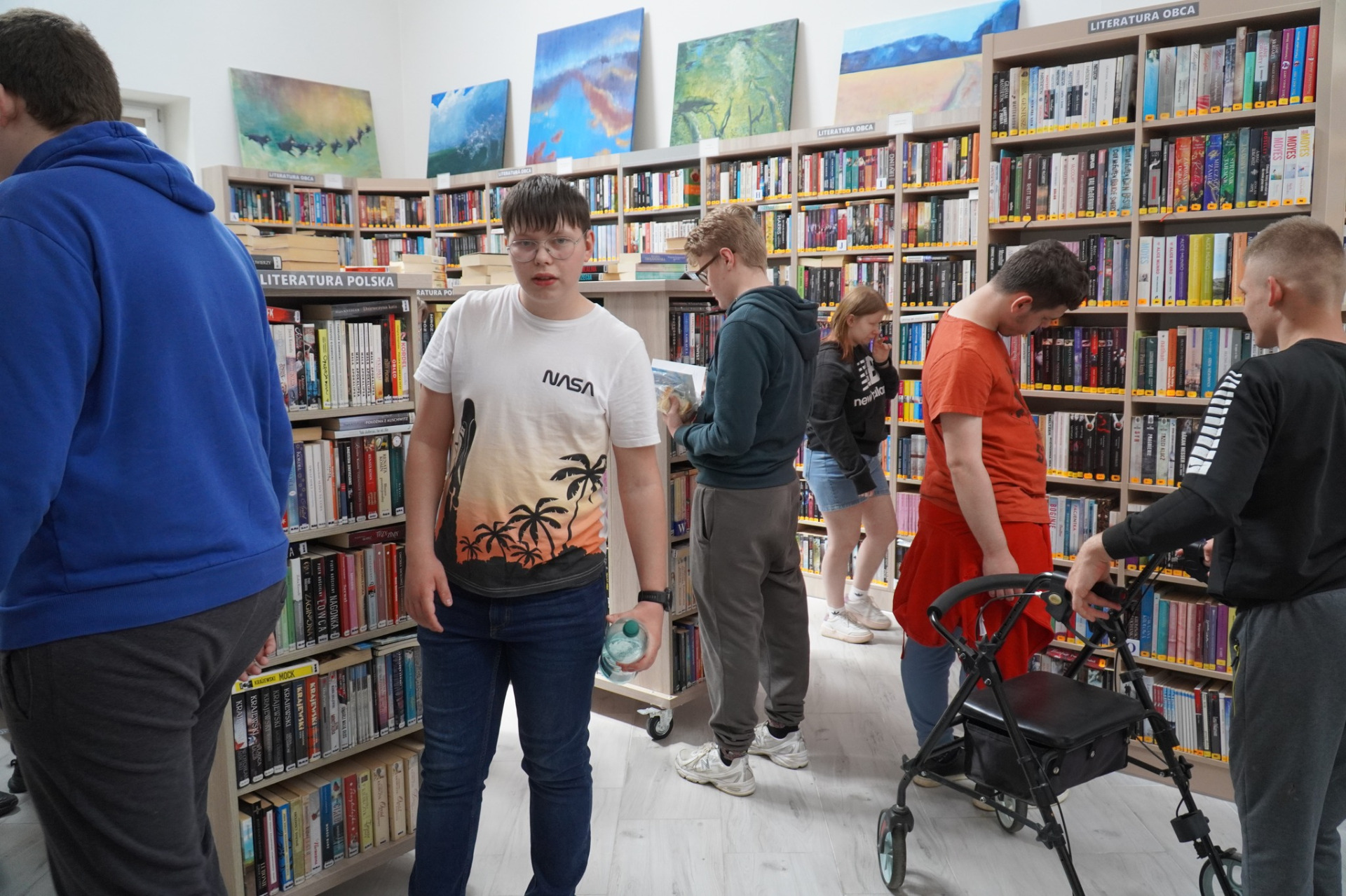 Młodzież z Ośrodka Szkolno - Wychowawczego w Olbięcinie zapoznaje się z księgozbiorem biblioteki. 