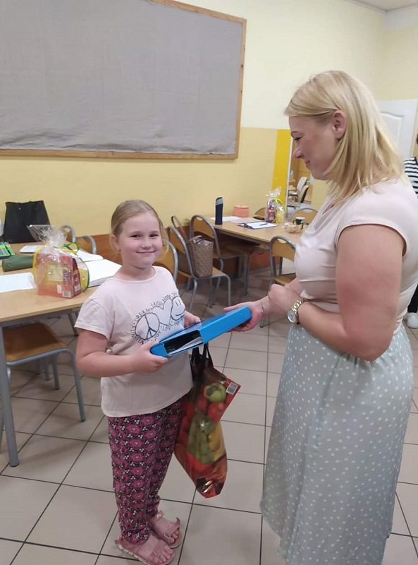 Kierownik GOPS wręcza paczkę dziewczynce