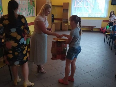 Kierownik GOPS wręcza paczkę dziewczynce