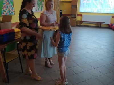 Kierownik GOPS wręcza paczkę dziewczynce