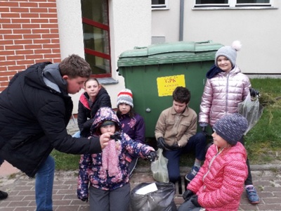 dzieci wyrzucają śmieci do kosza 