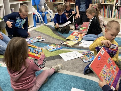 dzieci przeglądają książki w bibliotece