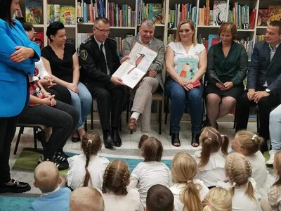 komendant straży gminnej czyta dzieciom
