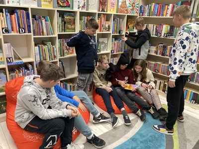 Dzieci przeglądają księgozbiór w bibliotece