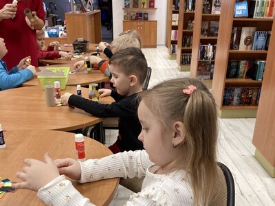 dzieci wyklejają papierowego wilka