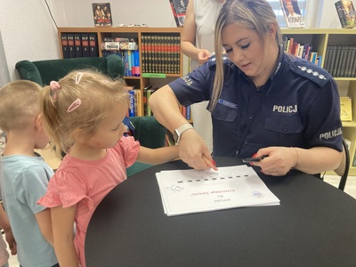 przedszkolaki w bibliotece podczas zajęć z policjantką