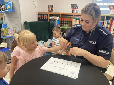 przedszkolaki w bibliotece podczas zajęć z policjantką