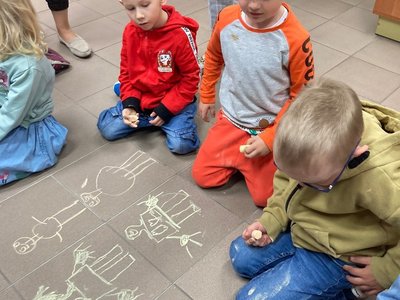 Chłopcy rysują portrety Mam na podłodze