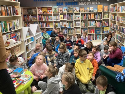 uczniowie siedzący na dywanie