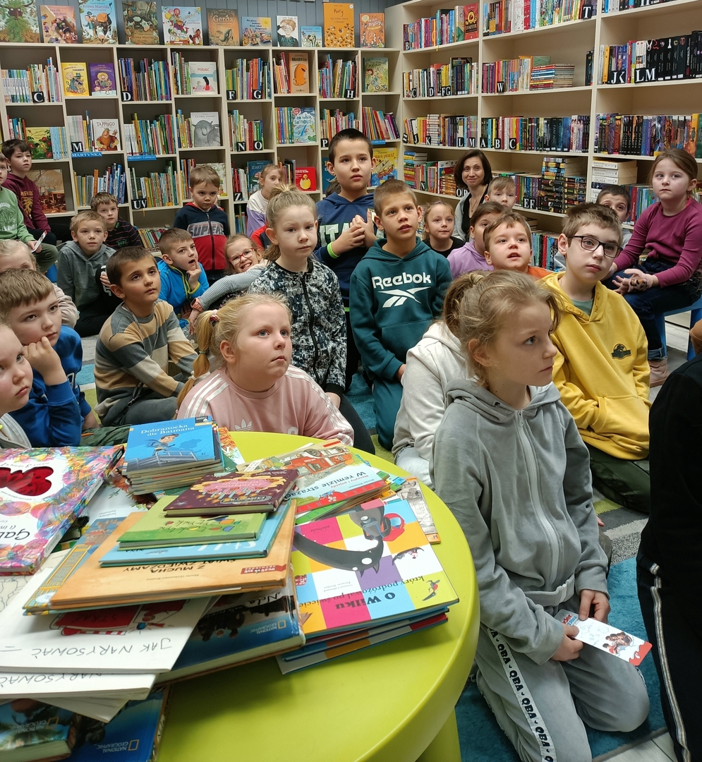uczniowie siedzący na dywanie