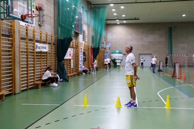 Mężczyzna rzucający piłką do kosza w hali widowiskowo-sportowej w Rakoniewicach