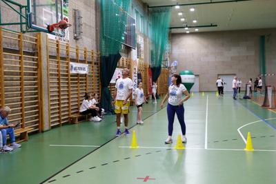 Kobieta rzucająca piłką do kosza w hali widowiskowo-sportowej w Rakoniewicach