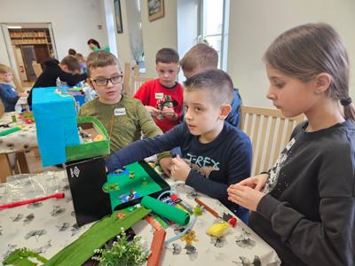 Dzieci przygotowujące swoje prace w pudełkach po butach  