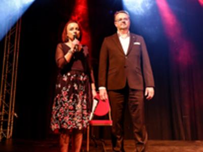Na zdjęciu znajduje się Dyrektor Rakoniewickiego Ośrodka Kultury - Gizela Ziółkowska wraz z Zastępcą Burmistrza - Arkadiuszem Pawłowskim. Dyrektor wita przez mikrofon gości. 