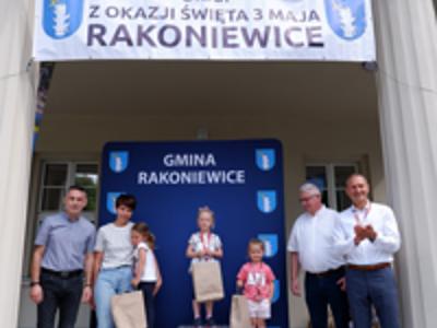 Zdjęcie grupowe dziewczyn na podium z Burmistrzem gm. Rakoniewice, Przewodniczącym oraz Zastępcą Przewodniczącego Rady Miejskiej.