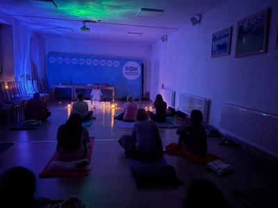 Uczestnicy siedzący na matach 