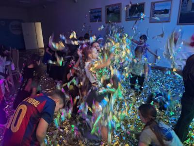 Tańczące dzieci w złotych serpentynach