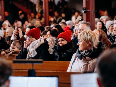 Zebrani ludzie siedzący w ławkach w kościele