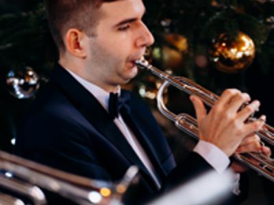 Zbliżenie na młodego mężczyznę grającego na trąbce