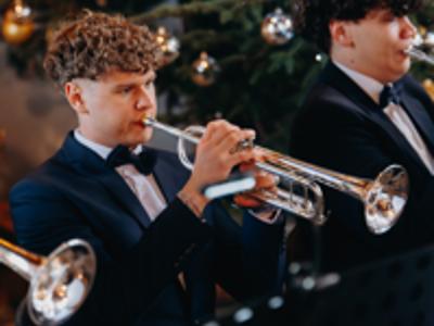 Zbliżenie na młodego mężczyznę grającego na trąbce