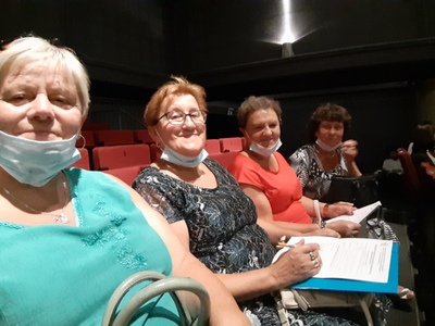 Cztery kobiety, seniorki siedzące w fotelach teatralnych