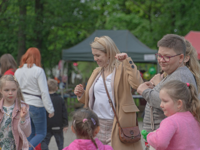 Grupka kobiet i dzieci stojąca na tle innych osób.