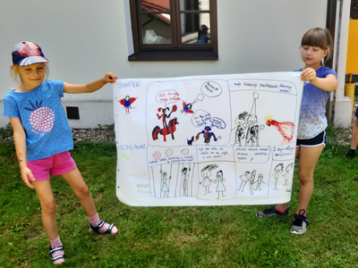 Dzieci trzymające dużą kartkę z narysowanym komiksem