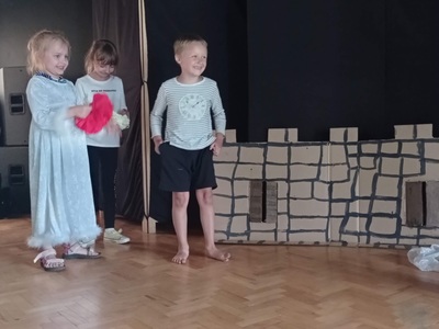 trójka uśmiechniętych dzieci na scenie