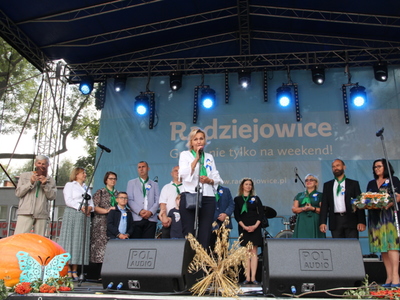 Zdjęcie sceny, na której stoi grupa elegancko ubranych osób.