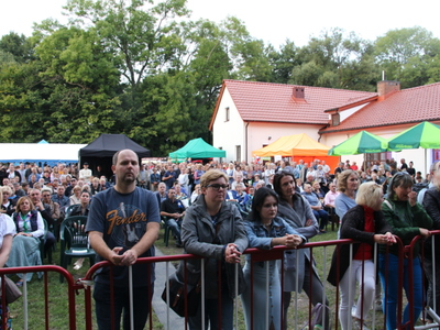 Grupa osób stojąca pod sceną.