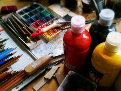 zdjęcie stołu z butelkami farb i przyborami do malowania