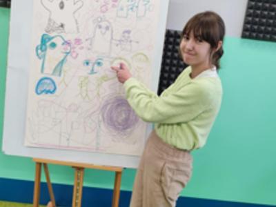 Z uśmiechami na twarzach dzieci w Radzijeowicach rysują „Ducha Szkoły”, używając wskazówek Kateriny Sheda jako inspiracji.