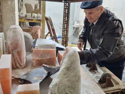 Na fotografii starszy mężczyzna przygląda się bryłom soli przed obróbką.