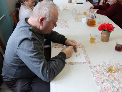 Zdjęcie przedstawia jednego z seniorów rozwiązującego quiz na temat kobiet i mężczyzn.