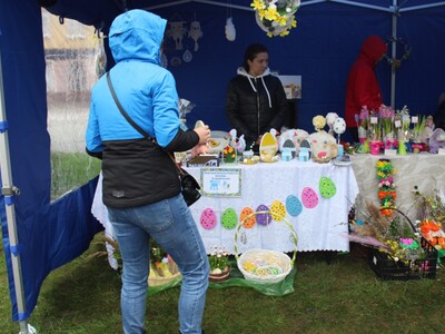 Na fotografii widać osobę odwiedzającą wystawę prac wielkanocnych podczas kiermaszu.