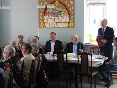 Na zdjęciu widać mężczyznę – jednego z zaproszonych gości, który w pozycji stojącej przemawia do wszystkich obecnych.