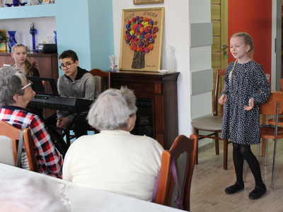 Zdjęcie przedstawia dziewczynę ze skrzypcami, chłopca przy keyboardzie oraz dziewczynkę śpiewającą piosenkę.